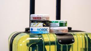 A suitcase with tubs of nicotine pouches.